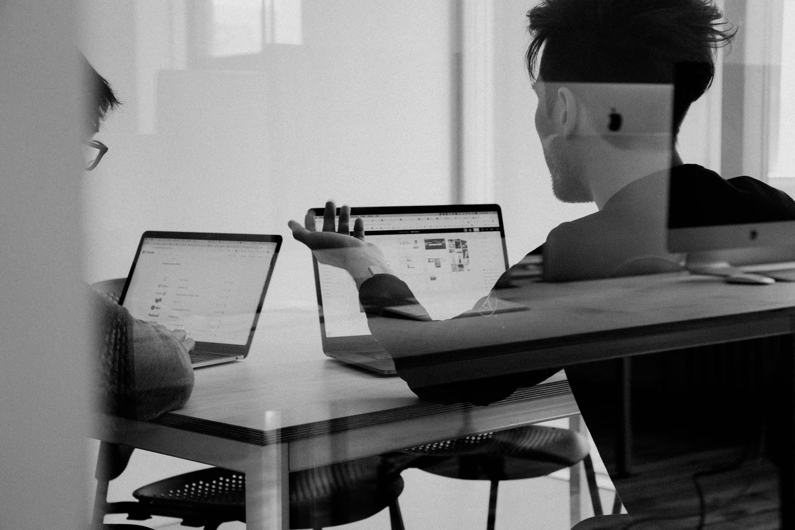 Two marketing strategists discussing organic and paid growth strategy in a meeting
